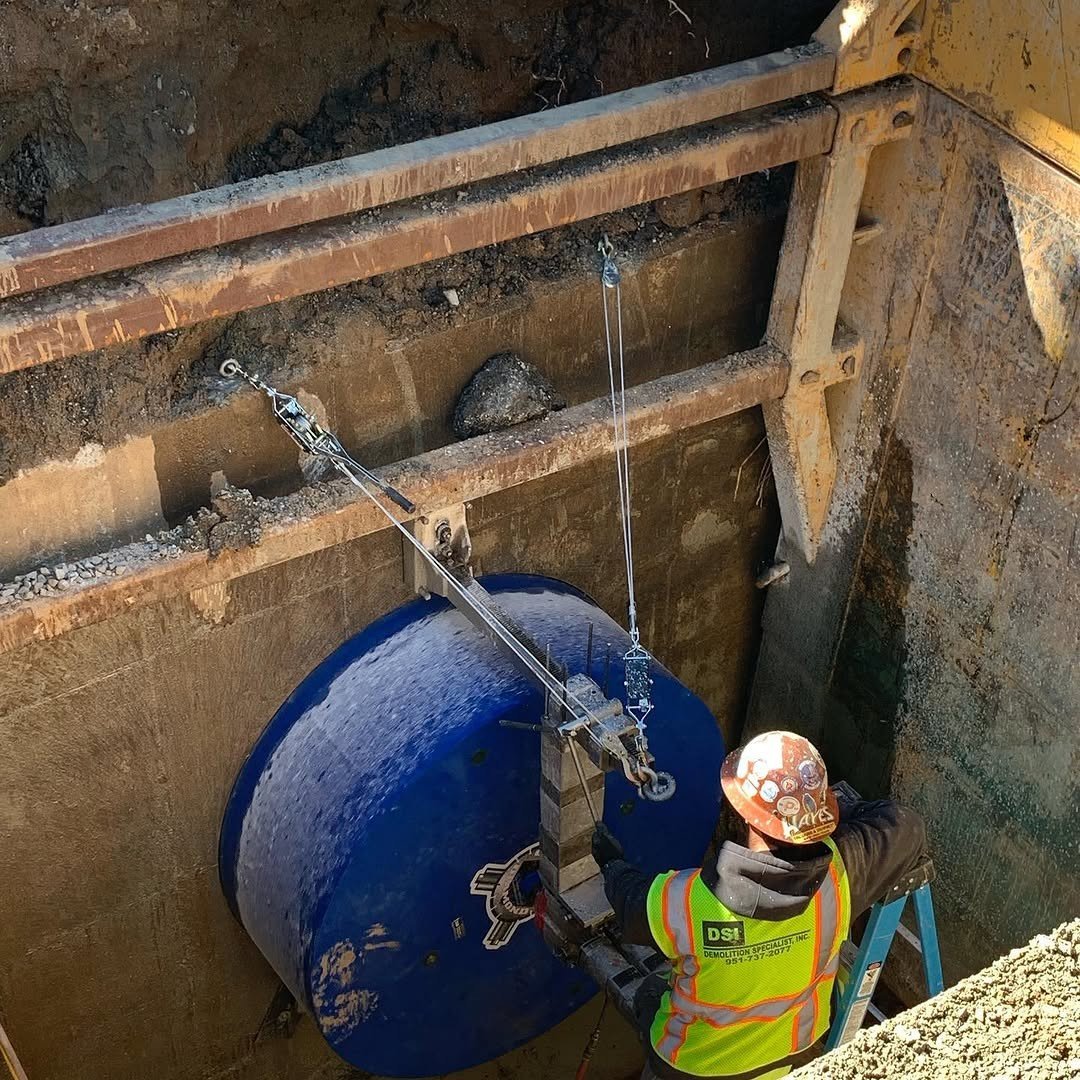 DSI worker core drilling through heavily reinforced concrete with rebar cage visible